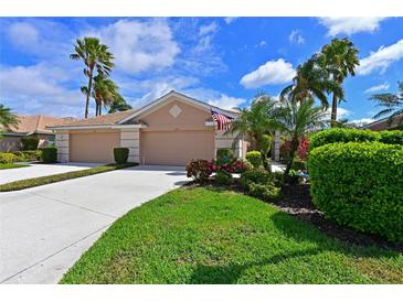 Charming home with a well-manicured lawn, lush landscaping, and a welcoming double garage at 379 Fairway Isles Ln, Bradenton, FL 34212