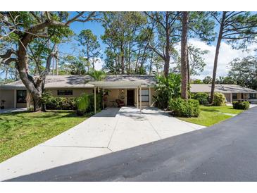 Charming home with a covered front entry, complemented by lush landscaping and a spacious driveway at 4843 Village Gardens Dr # 176, Sarasota, FL 34234