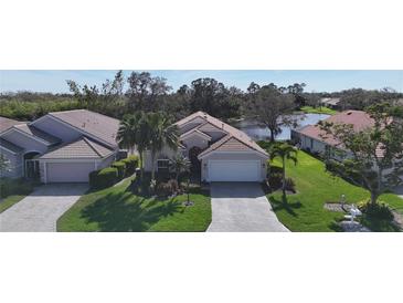 Charming single-story home with well-manicured lawn, lush landscaping, and a two-car garage at 5242 Highbury Cir, Sarasota, FL 34238
