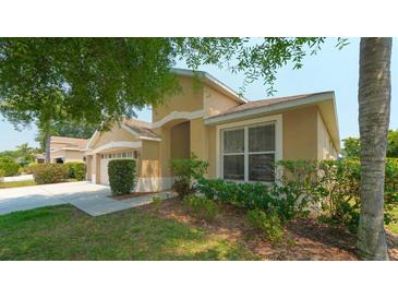 Charming single-story home featuring a stucco facade, lush landscaping, and an attached two-car garage at 5453 New Covington Dr, Sarasota, FL 34233