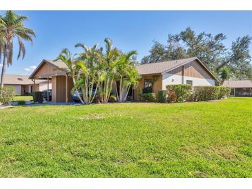 Charming single-story home with mature palm trees and well-maintained lawn on a sunny day at 1709 Curry Trl # 30, North Venice, FL 34275