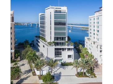 Modern condo building boasts stunning waterfront views, sleek architecture, and lush landscaping at 280 Golden Gate Pt # 400, Sarasota, FL 34236