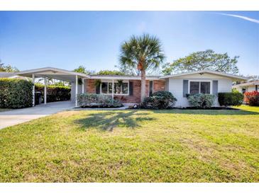 Charming single-story home featuring a well-manicured lawn and a convenient carport at 3042 Lockwood Ter, Sarasota, FL 34231