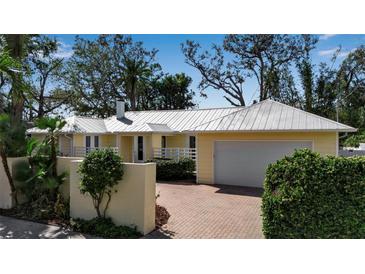 Charming single-story home with well-manicured landscaping and a brick driveway at 980 S Orange Ave, Sarasota, FL 34236