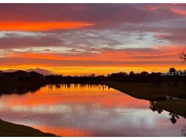 Beautiful sunset reflecting on a pond, painting the sky with vivid orange and purple hues at 12534 Nantahala Run Run, Parrish, FL 34219