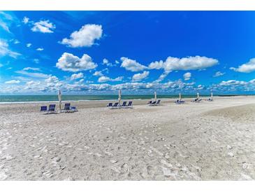 Scenic beach view featuring multiple beach chairs and umbrellas near the shoreline at 1465 Gulf Of Mexico Dr # 104, Longboat Key, FL 34228