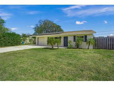 Inviting single-story home with a lush green lawn and mature landscaping at 3715 Bond Pl, Sarasota, FL 34232