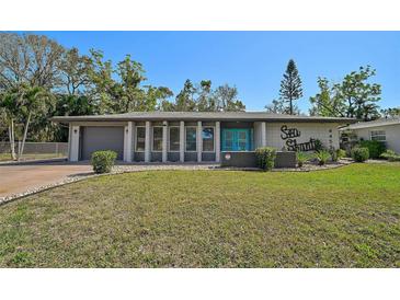 Charming single-story home with blue front door, well-maintained lawn, and lovely landscaping at 4455 Emerald Ridge Dr, Sarasota, FL 34233