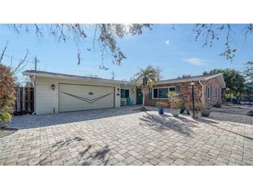 Charming brick and siding home featuring a large, paved driveway and a well-manicured front yard at 5525 Shadow Lawn Dr, Sarasota, FL 34242