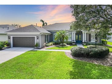 Charming single-story home with a lush green lawn, manicured landscaping, and a two-car garage at 8014 Planters Knoll Ter, Bradenton, FL 34201