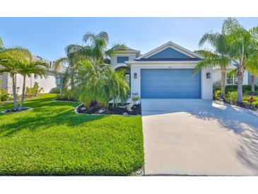 Charming single-story home with a well-maintained lawn, palm trees, and a blue garage door at 4516 Renwick Dr, Parrish, FL 34219