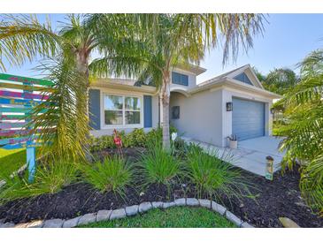Charming single-Gathering home with lush landscaping, blue shutters, and a two-car garage at 4516 Renwick Dr, Parrish, FL 34219