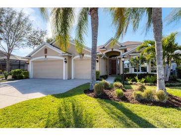 Inviting single-Gathering home featuring lush landscaping, a well-manicured lawn, and a spacious three-car garage at 4724 Tilden Park Ct, Bradenton, FL 34211