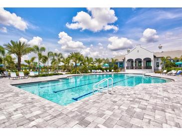A luxurious community pool surrounded by lounge chairs and palm trees offers a relaxing atmosphere at 2720 Butterfly Jasmine Trl, Sarasota, FL 34240