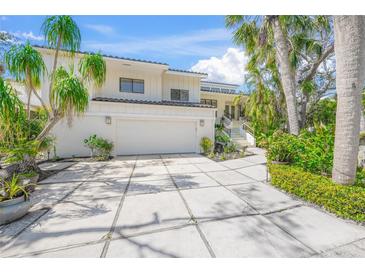 Stunning two-story home with a wide driveway, two-car garage, and lush tropical landscaping at 3421 Bayou Sound, Longboat Key, FL 34228
