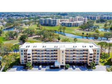 A beautiful multi-story condo building overlooks a lush golf course and serene water feature, creating an idyllic living environment at 3750 Pinebrook Circle # Apt 505, Bradenton, FL 34209