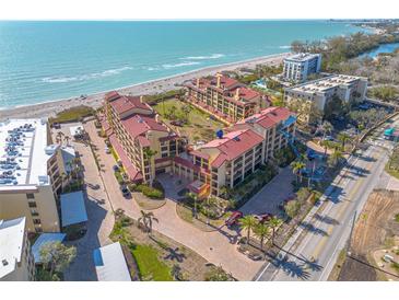 Stunning aerial view of the beachside condo complex with lush landscaping and beachfront access at 8710 Midnight Pass Rd # 501B, Sarasota, FL 34242