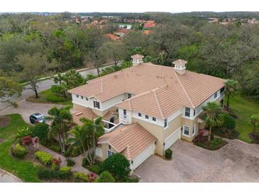 Stunning aerial view of home with tile roof, lush landscaping, and brick driveway at 9460 Discovery Ter # 202D, Bradenton, FL 34212