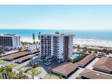 Beautiful aerial view of a beachfront condo with a pool, lush landscaping, and beach access at 101 Benjamin Franklin Dr # 63, Sarasota, FL 34236