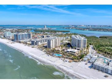Stunning aerial view showcasing beachfront condos, pristine white sands, and turquoise waters on a sunny day at 1300 Benjamin Franklin Dr # 304, Sarasota, FL 34236