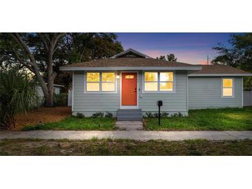Charming single-story home featuring a light-blue facade, orange front door and well-manicured landscaping at 1739 16Th S Ave, St Petersburg, FL 33712