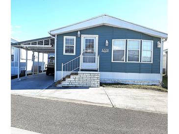Charming blue single-Gathering home featuring a carport, well-maintained landscaping, and a welcoming entrance at 3333 26Th E Ave # 1220, Bradenton, FL 34208