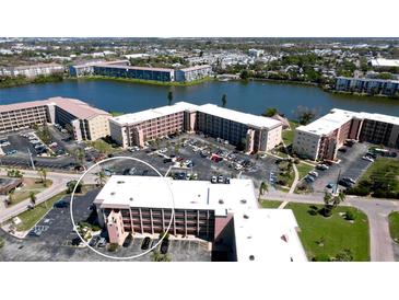 An aerial view of the condo community with multiple buildings, parking, and a waterfront view of the lake at 4133 Heron Way # E202, Bradenton, FL 34205