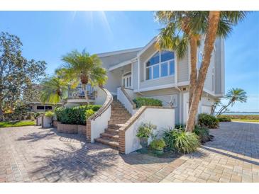 Inviting coastal home showcasing a brick stairway and lush landscaping at 44 Tidy Island Blvd, Bradenton, FL 34210