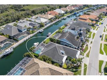 Stunning aerial view of waterfront property featuring a private pool, boat dock, and lush tropical landscaping at 581 Mast Dr, Bradenton, FL 34208