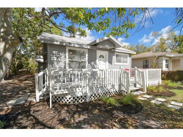 Charming gray cottage-style home with a white picket fence and inviting front porch and stepping stones at 701 37Th Avenue E Dr, Bradenton, FL 34208