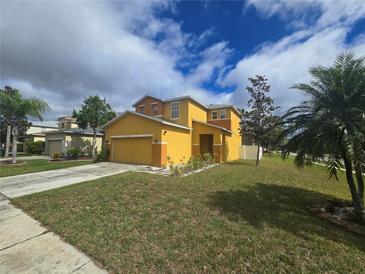 Two-story home featuring a well-manicured lawn and bright yellow and orange paint scheme at 9112 Bell Rock Pl, Land O Lakes, FL 34638