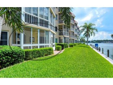 Waterfront condo with lush green lawn, landscaping and screened in lanai overlooking the water at 1350 N Portofino Dr # 108, Sarasota, FL 34242