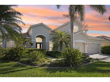Stunning home exterior with a well-manicured lawn and lush tropical landscaping in a quiet neighborhood at 1655 Pinyon Pine Dr, Sarasota, FL 34240