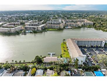This aerial view captures a lakeside community with multiple buildings, a lake, and a parking lot at 3424 Lake Bayshore Dr # 405, Bradenton, FL 34205