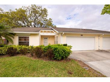 Inviting villa showcasing lush landscaping, a covered entryway, and an attached two-car garage, enhancing curb appeal at 4018 Oakhurst Dr # 3181, Sarasota, FL 34233