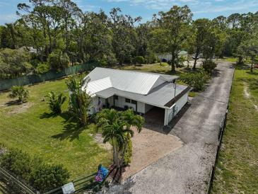 An aerial view of a charming home boasting lush landscaping, mature trees and a long driveway at 4116 34Th E Ave, Bradenton, FL 34208