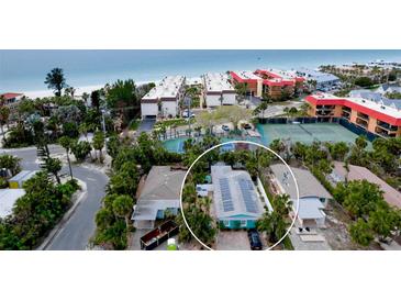 Charming coastal home near the beach featuring solar panels and lush tropical landscaping at 5802 De Palmas Ave, Holmes Beach, FL 34217