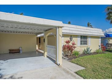 Charming single-story home featuring a carport, well-maintained landscaping, and a bright, welcoming facade at 5869 Tidewood Ave # 7, Sarasota, FL 34231