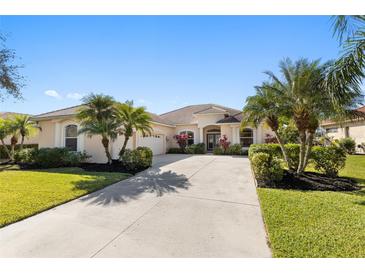 Spacious single-story home with a tile roof, long driveway, manicured landscaping, and palm trees at 12736 Penguin Dr, Bradenton, FL 34212