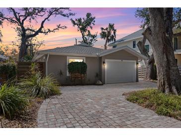 Charming single-story home featuring a brick driveway and attached one car garage with beautiful lush landscaping at 1622 Wisconsin Ln, Sarasota, FL 34239