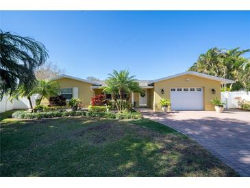 Charming single-story home with a manicured lawn, mature landscaping, and a brick paver driveway at 1940 35Th N St, St Petersburg, FL 33713