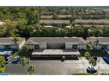 Aerial view of the condo building featuring covered parking and mature trees at 2851 Swifton Dr # 39, Sarasota, FL 34231