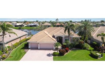 Waterfront single-story home featuring a three-car garage and tropical landscaping at 2879 Grazeland Dr, Sarasota, FL 34240