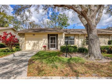 Charming single-story home features a lush lawn, a covered porch, and a one-car garage at 4223 Oakhurst E Cir # 3025, Sarasota, FL 34233