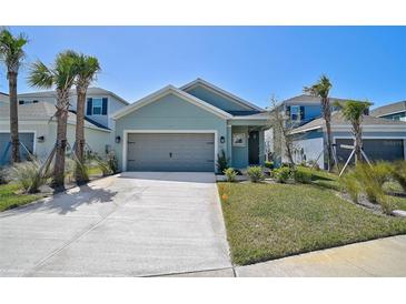 Charming single Gathering home featuring a two-car garage, manicured lawn, and beautiful landscaping at 5675 Equator Ct, Nokomis, FL 34275