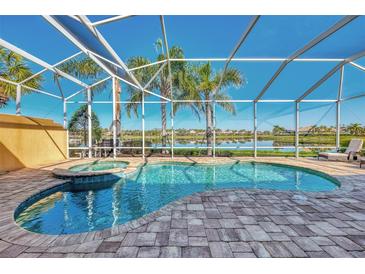 Inviting screened pool area overlooking the lake, with brick pavers and jacuzzi tub at 5916 Mariposa Ln, Sarasota, FL 34238