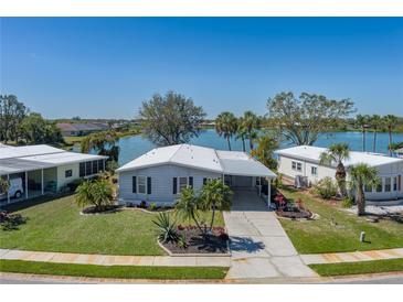 Waterfront property with well-manicured lawn, lush landscaping, and stunning lake views from this cozy home at 8409 Imperial Cir, Palmetto, FL 34221
