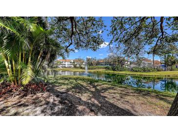 Scenic view of a pond with a fountain, surrounded by lush greenery and residential buildings at 850 S Tamiami Trl # 307, Sarasota, FL 34236