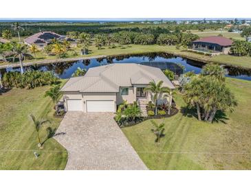 Stunning waterfront home with lush landscaping and a paver driveway at 16211 Cayman Ln, Punta Gorda, FL 33955