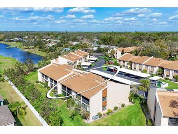 An aerial view of a condominium complex near a lake and green spaces provides a serene and appealing living environment at 2446 Clubhouse Cir # 202, Sarasota, FL 34232